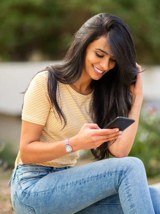 attractive-woman-sitting-outside-looking-at-mobile